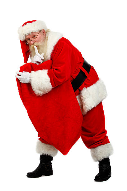 santa carying his sack santa tiptoeing as he says shush with his sack in hand santa claus expressions shhh stock pictures, royalty-free photos & images