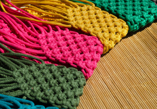 istock Small handbags knitted with macrame technique on a bamboo background. 1525176744