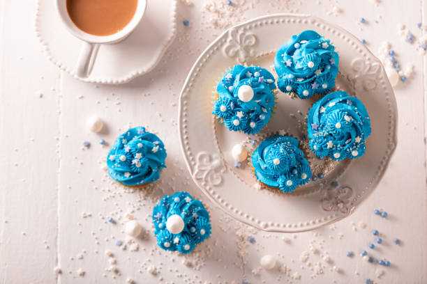 Delicious and sweet cupcakes with blue whipped cream. Perfect blue dessert with sprinkles.