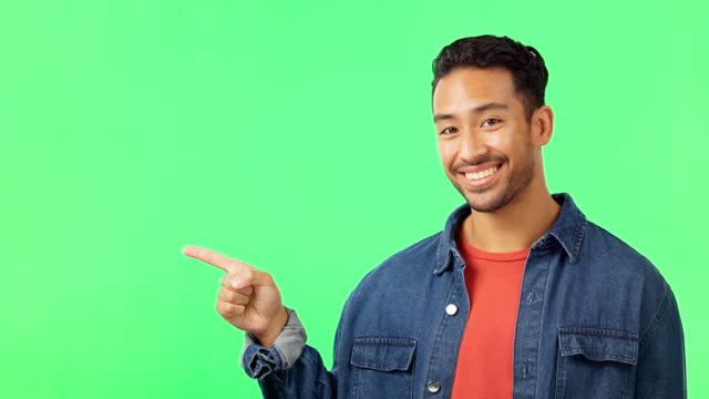 Smile, face and man hand pointing to green screen studio for commercial promotion, advertising and mockup. Portrait, happy and asian male showing space, product placement and isolated copy space