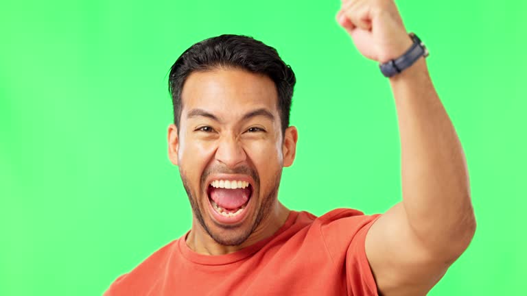 Man, excited with fist pump and celebration on green screen, winning and success with happiness. Portrait, yes and male with achievement, mockup with cheers and winner energy on studio background