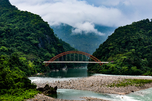 Wahrew Bridge in Meghalaya. With river of green color , mountains and clouds .