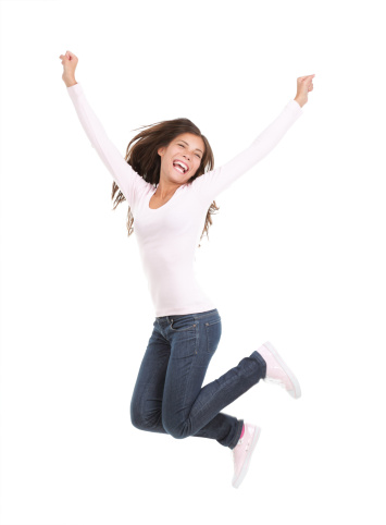 Happy woman jumping. Excited young woman jumping of joy. Full length portrait of mixed race chinese / caucasian model isolated on seamless white background. Click for more: