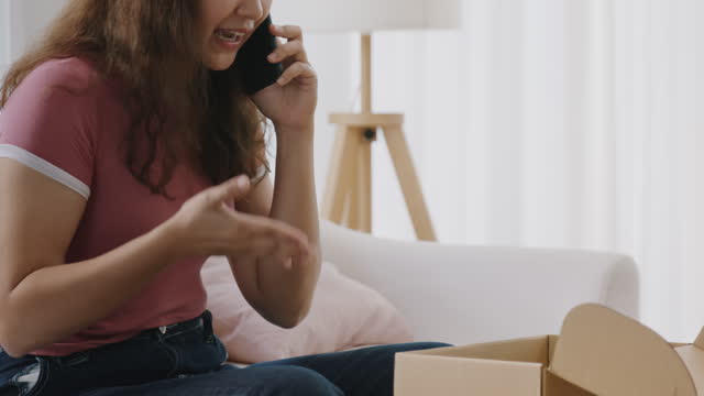 Asian woman displeased customer unhappy delivery phone call complain.