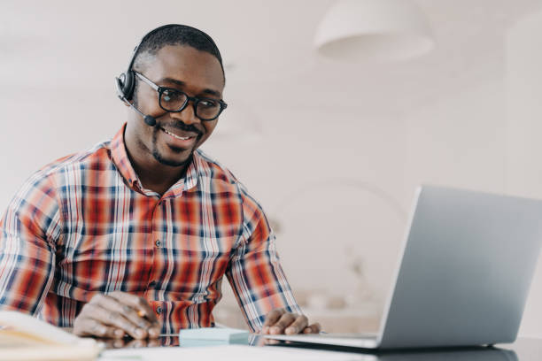 istock Happy African American man in wireless headset studying online on laptop, enjoying e-learning and distance education. 1525360538