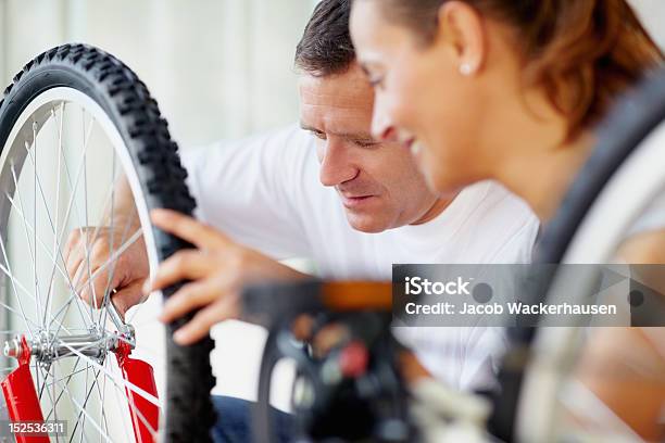 Medio De Hombre Arreglando Un Neumático Con Esposa Bicicleta Foto de stock y más banco de imágenes de Bicicleta