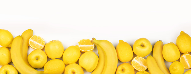 Set of yellow color fruits. Apples, lemons and bananas on a white background with a copy space