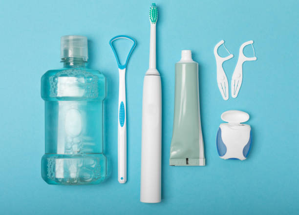 Electronic ultrasonic toothbrush, mouthwash, floss, tongue cleaner and toothpaste on blue textured background. Items for dental care and caries prevention in the bathroom. Dentistry concept. Copy spac cepillo de dientes ultrasónico electrónico, enjuague bucal, hilo dental, limpiador de lengua y pasta de dientes sobre fondo de textura azul. artículos para el cuidado dental y la prevención de caries en el baño. concepto de odontología. espacio de co