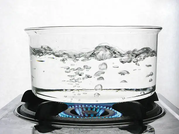 Water boiling in a clear glass pot.