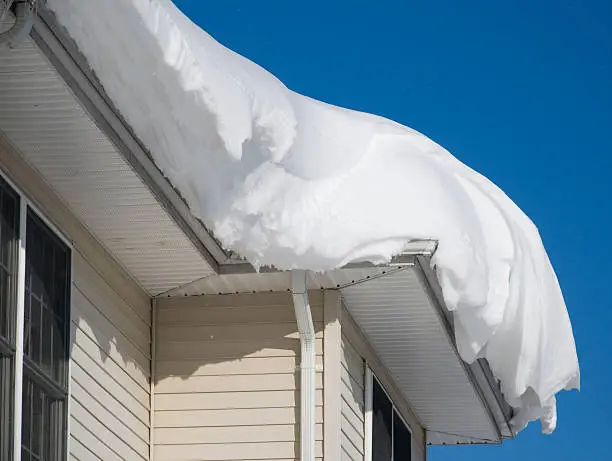 Photo of Thick pile of snow on the rooftop of a house