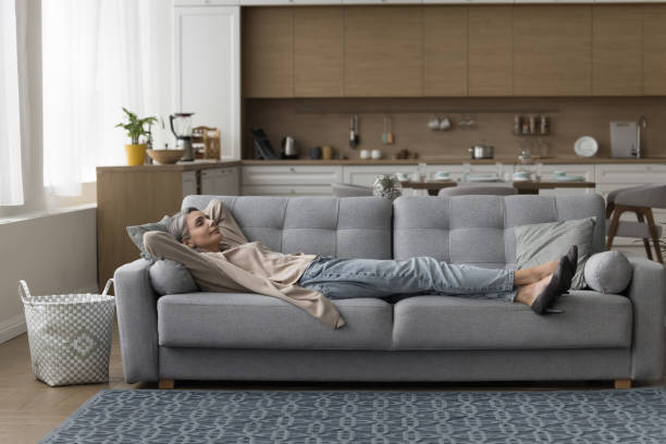 istock Calm sleepy mature lady lying on sofa with closed eyes 1525380432