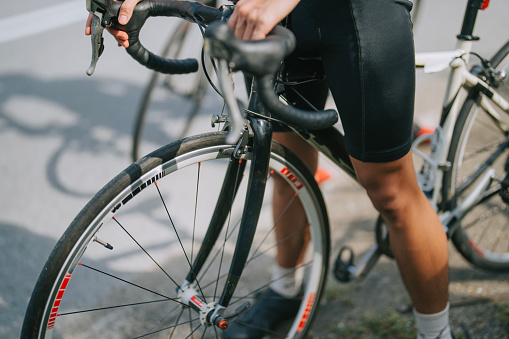 close up Asian chinese cyclist getting ready at roadside during weekend morning