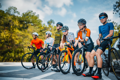 Group portrait of Asian Chinese cyclist looking away in the middle of road with cool attitude rural scene