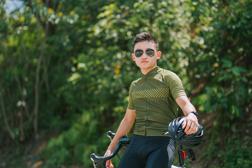 Portrait asian chinese male cyclist at rural scene in weekend morning
