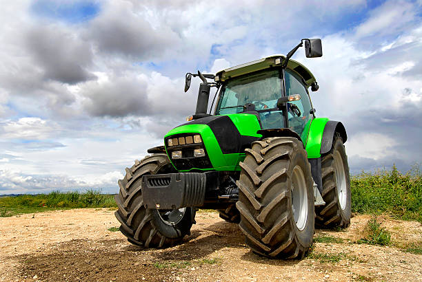 istock A green tractor under looming gray clouds outside 152538185