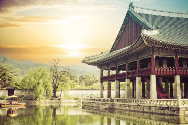 A building on the grounds of  Gyeongbokgung Palace in Seoul, South Korea with a pond.  This image is developed to give the impression that it is very old.
