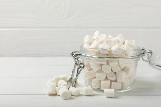 istock Marshmallow in a glass bowl on a white texture background.Rustic style.Gummous candy close-up.Snacks and snacks for parties.Spice for coffee and cocoa.Winter food concept.Place for text.Place for copy 1525393360
