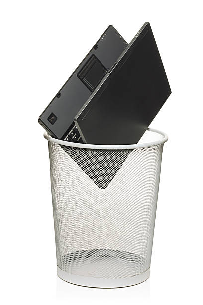 Laptop in a trash bin Laptop in a trash bin isolated against white background laptop in a trash bin stock pictures, royalty-free photos & images