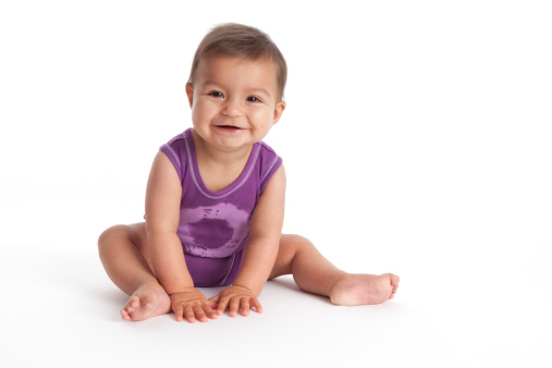 Happy Baby girl sitting on the floor on white background