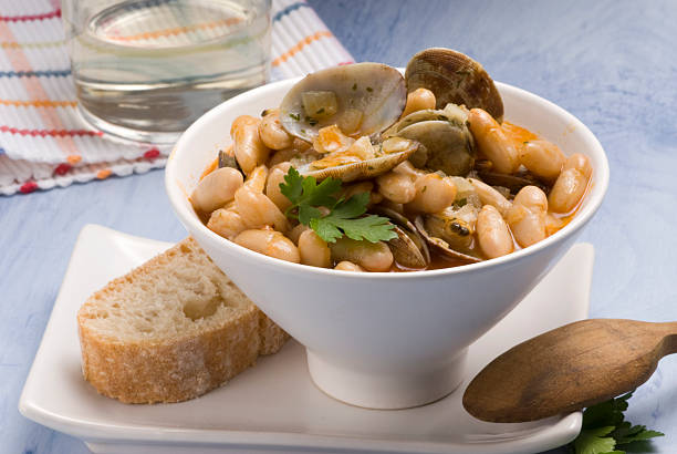 Asturian clams and beans. Spanish cuisine. Fabes con almejas. Asturian clams and beans stew served in a white bowl. Spanish cuisine. Selective focus. Fabes con almejas. fabes stock pictures, royalty-free photos & images