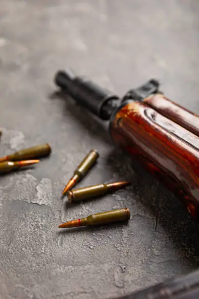 Photo of Bullets and ammo magazine with kolashnikov assault rifle on texture marble.Composition with place for text.Rifle and carbine cartridges on wooden background.Military concept.Copy space