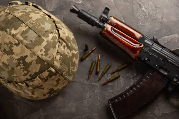 Photo of Bullets and ammo magazine with kolashnikov assault rifle on texture marble.Composition with place for text.Rifle and carbine cartridges on wooden background.Military concept.Copy space