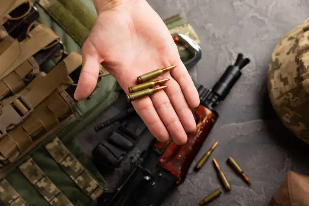Photo of Bullets and ammo magazine with kolashnikov assault rifle on texture marble.Composition with place for text.Rifle and carbine cartridges on wooden background.Military concept.Copy space