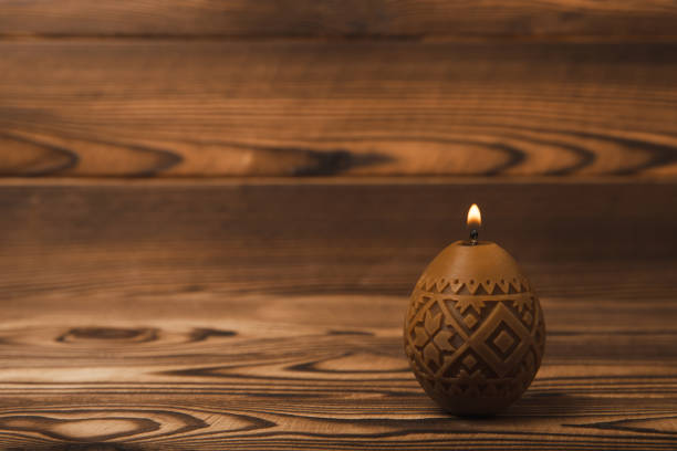 Easter candle eggs and willow branches on a brown textural background. Easter holiday concept.Spring willow bouquet.Decor for home and festive steel.Copy space. Place for text.