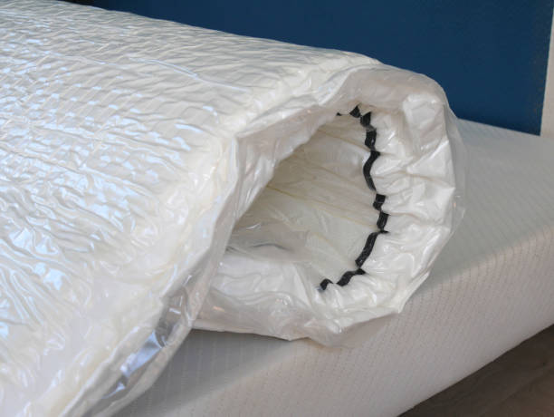 installation d’un matelas roulé sous vide sur un lit - roll away bed photos et images de collection