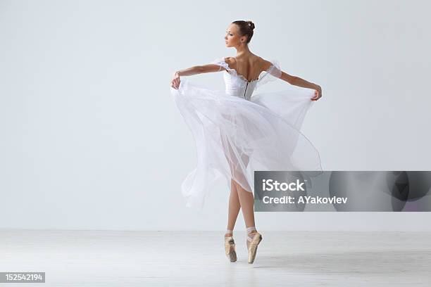 Beautiful Dancer In White Holding Her Gown On Her Toes Stock Photo - Download Image Now