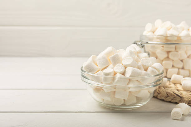 istock Many different marshmallows in bowls and jars on a white textured wood. White and fruit marshmallow. Sweets and snacks for a snack. Chewing candies close-up. Copy space. Place for text. 1525424781