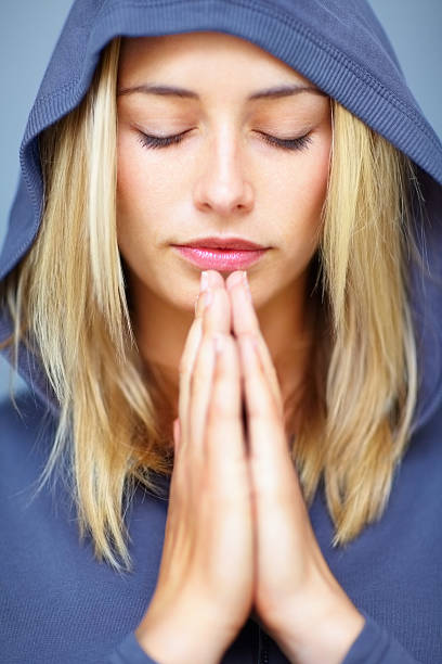istock Caucasian young lady praying with hands joined 152543027