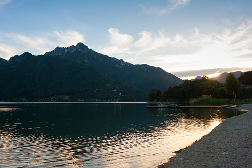 Sunset over Lago di Ledro, Trento, Italy. Landing pier with boats on the foreground.