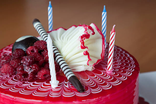 raspberry cake with four candles stock photo