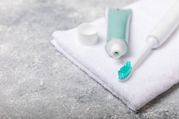 Electronic ultrasonic toothbrush, mouthwash, floss, tongue cleaner and toothpaste on white wooden background. Items for dental care and caries prevention in the bathroom. Dentistry concept. Copy space cepillo de dientes ultrasónico electrónico, enjuague bucal, hilo dental, limpiador de lengua y pasta de dientes sobre fondo de madera blanca. artículos para el cuidado dental y la prevención de caries en el baño. concepto de odontología. espacio de c