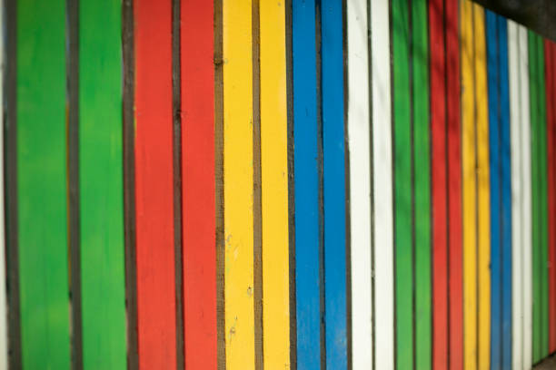 Colored fence. Beautiful fence. Different color on boards. Painted material. Design Details.