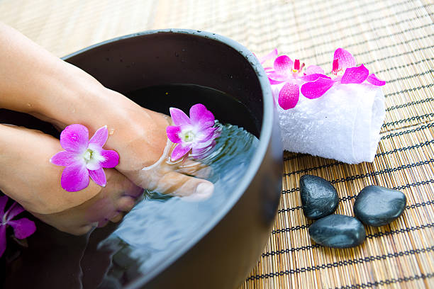 istock feet in foot spa bowl with orchids 152545104