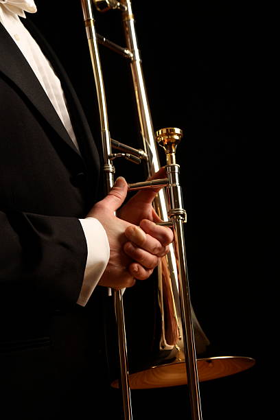 istock Musician holds a trombone against  black background 152545167