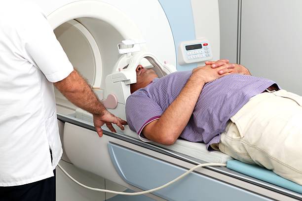 Patient have an MRI scan Preparing a patient for taking an MRI scan x ray image medical occupation technician nurse stock pictures, royalty-free photos & images