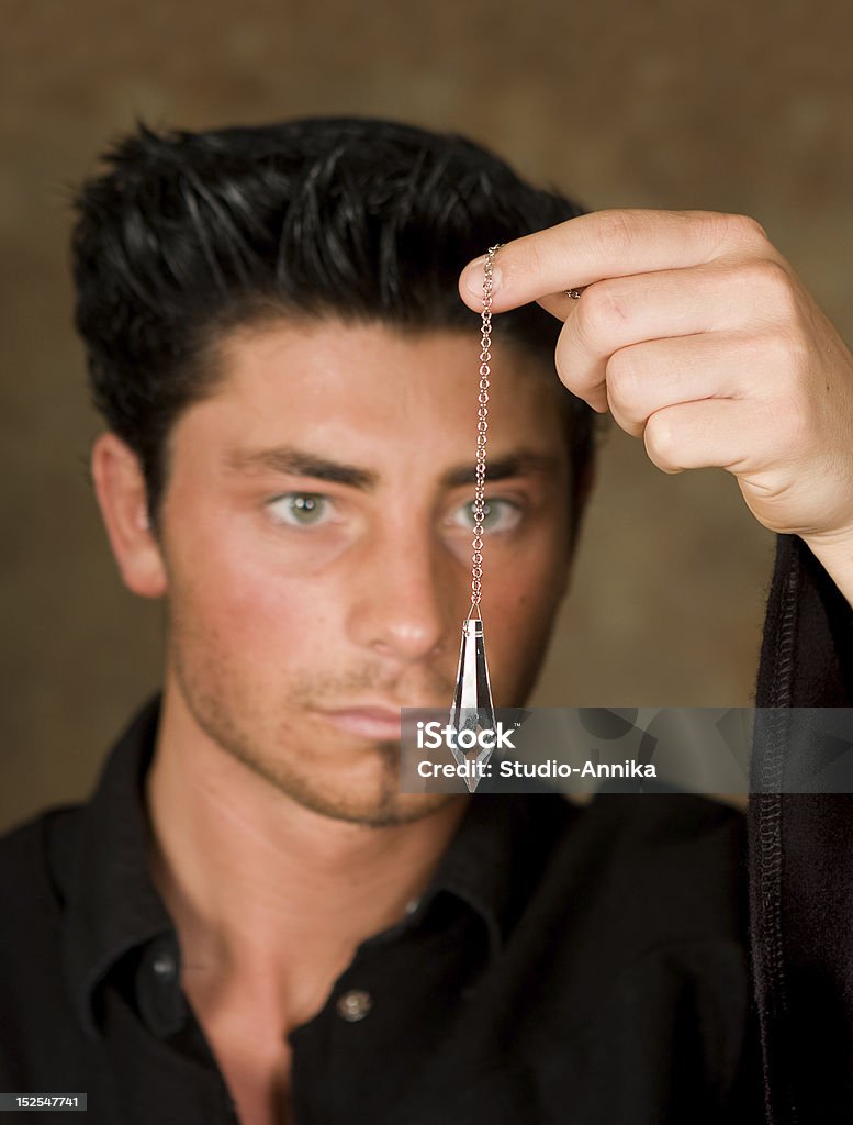 Focus on pendulum Crystal tarot pendulum against a blurred gypsy face Crystal Stock Photo