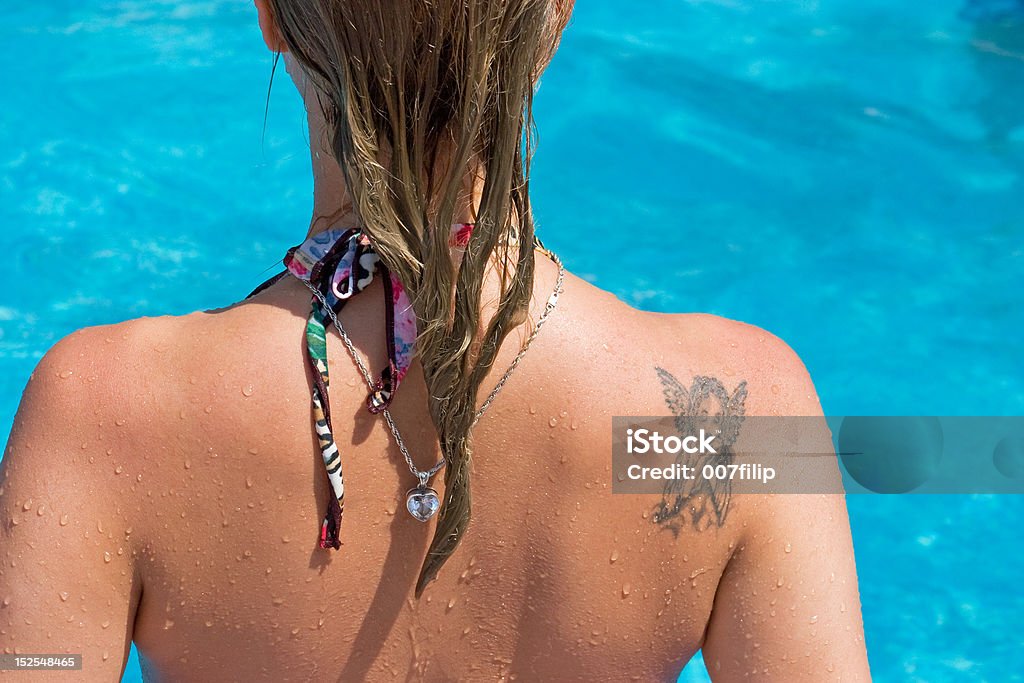 Girls back Back of a blond girl with tattoo in the swimming pool Tattoo Stock Photo