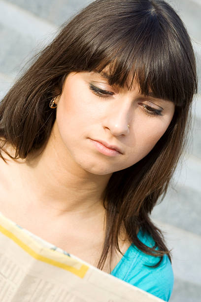 istock Young woman reading a newspaper 152548484