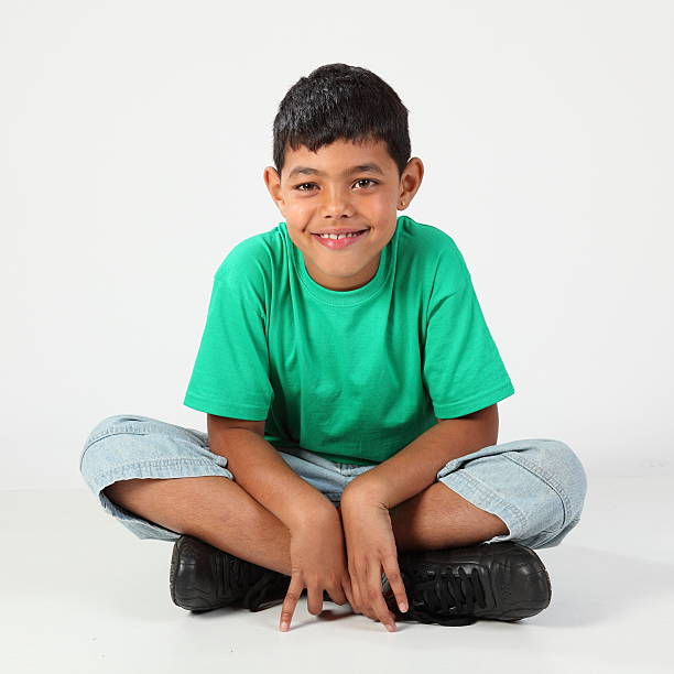 istock Smiling school boy 9 sitting cross legged on floor 152548533