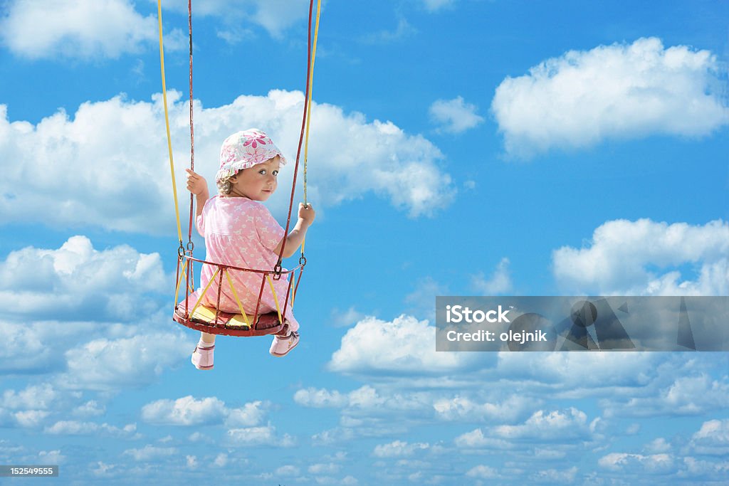 swinging happy cute girl swinging in blue summer sky, clipping path for girl Activity Stock Photo