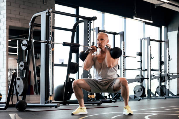istock Squats with kettlebells exercise. Middle aged athlete doing functional workout at the gym. 1525531176