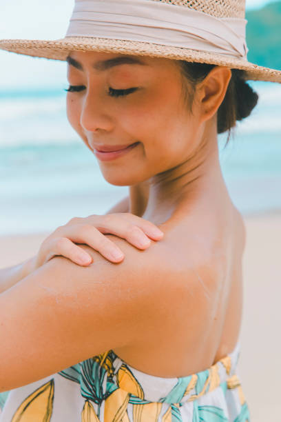 istock Safe Under the Sun: Tourist Woman Ensuring Sunscreen Coverage on the Beach 1525555836