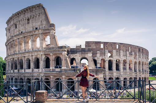 woman posing in front of the Roman coliseum