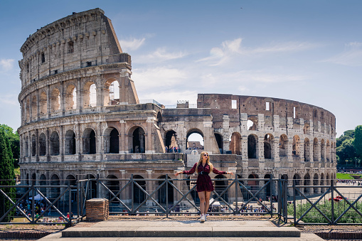 woman posing in front of the Roman Colosseum in Italy