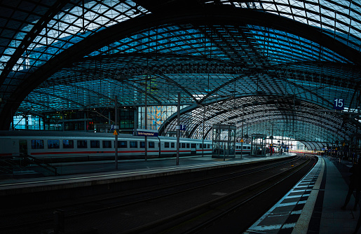 Abstract geometry of the metal and glass ceilings, poles, and railway tracks in Berlin Train Station in Germany