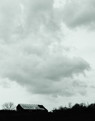 Gathering clouds around a barn and farm